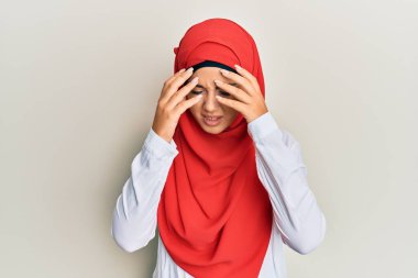 Genç ve güzel İspanyol bir kız geleneksel İslami başörtüsü takıyor. Başında baş ağrısı var çünkü stres var. migren ağrısı. 