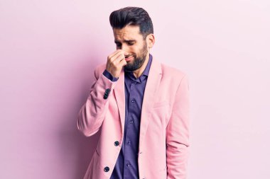 Sakallı, zarif ceketli genç yakışıklı bir adam pis ve iğrenç bir koku alıyor. Nefesini burnunda tutuyor. Kötü kokuyor. 