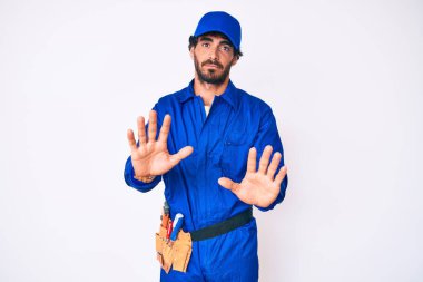 Kıvırcık saçlı ve ayı gibi giyinen yakışıklı genç adam. Avuçlarını kaldırıyor. Korkmuş ve iğrenç bir ifadeyle reddediyor. Dur ve yasakla. 