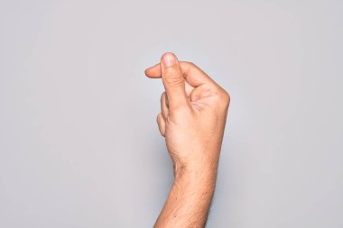 İzole edilmiş beyaz arka planda parmak, iş ve reklamla boş alan tutan beyaz bir gencin eli.