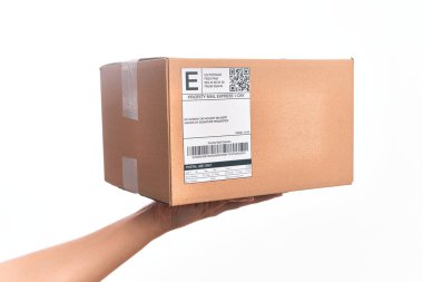 Beyaz arka plan üzerinde kod çubuğu olan karton bir paket taşıyan beyaz bir adam.