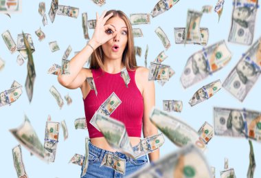 Zarif bir yaz gömleği giyen genç, sarışın bir kadın. Şaşırmış yüz ifadesiyle şaşırmış, parmaklarının arasından bakan bir jest yapıyor. İnançsız ifade.