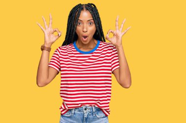 Gündelik kıyafetler giyen güzel İspanyol kadın şaşırmış ve şok olmuş görünüyor. Tamam sembolünü parmaklarıyla yapıyor. çılgın ifade 