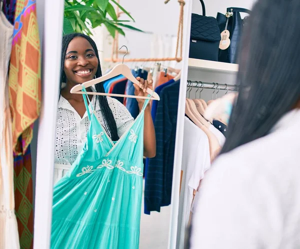 Junge Afroamerikanerin Lächelt Glücklich Und Hält Kleidung Vor Dem Spiegel — Stockfoto