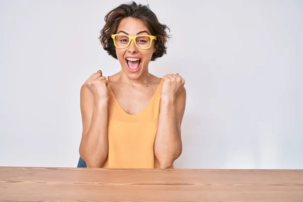 Gündelik Giysiler Gözlük Takan Genç Spanyol Kadın Masanın Üzerinde Oturmuş — Stok fotoğraf