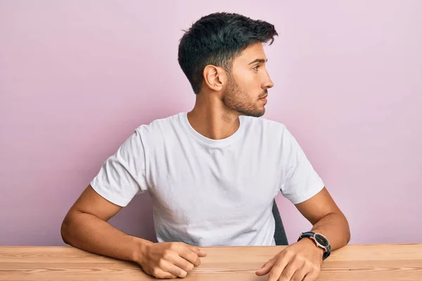 Joven Hombre Guapo Vistiendo Casual Camiseta Blanca Sentado Mesa Mirando — Foto de Stock