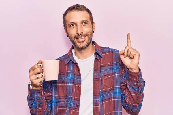 Joven Hombre Guapo Sosteniendo Café Sonriendo Con Una Idea Pregunta —  Fotos de Stock