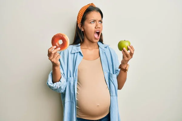 Mulher Hispânica Bonita Esperando Bebê Segurando Comida Irritada Louca Gritando — Fotografia de Stock