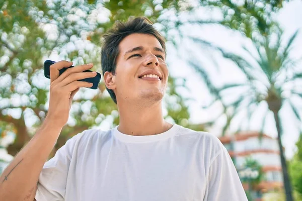 Jovem Caucasiano Sorrindo Feliz Ouvir Mensagem Áudio Usando Smartphone Cidade — Fotografia de Stock