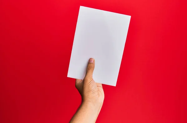 Mano Joven Hispano Sosteniendo Bandera Vacía Sobre Fondo Rojo Aislado — Foto de Stock