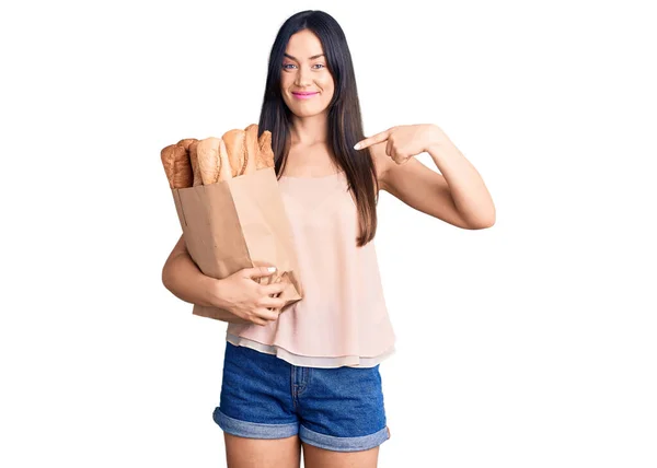 Junge Schöne Kaukasische Frau Hält Papiertüte Mit Brot Und Zeigt — Stockfoto