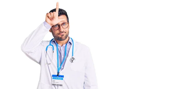 Jovem Hispânico Vestindo Uniforme Médico Estetoscópio Zombando Pessoas Com Dedos — Fotografia de Stock