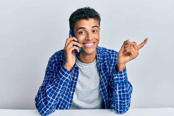 잘생긴 아프리카계 미국인 남자가 스마트폰으로 이야기하고 있습니다 손가락으로 가리키며 행복하게 — 스톡 사진