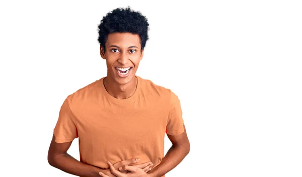 若いアフリカ系アメリカ人男性を身に着けているカジュアル服笑顔と笑いハードアウト大声でなぜなら面白いクレイジー冗談で手で体 — ストック写真