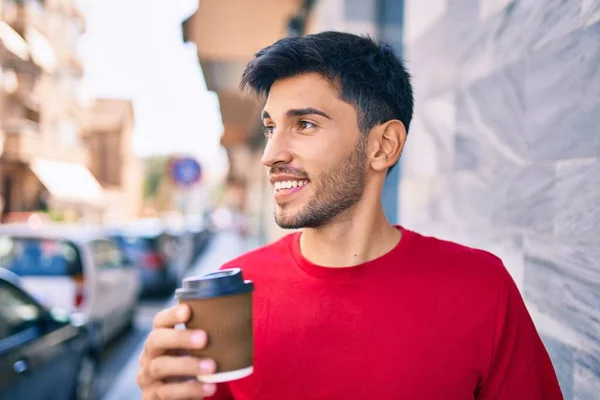 年轻的拉丁裔男子开心地微笑着 喝完咖啡就走在城里 — 图库照片