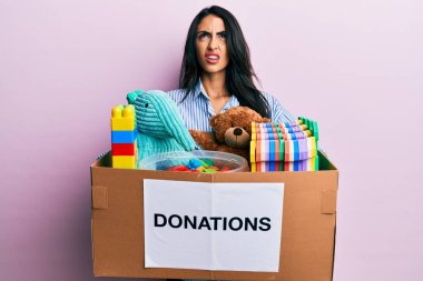 Güzel İspanyol kadın oyuncaklarla dolu bir bağış kutusu tutuyor kızgın ve öfkeli çığlıklar atıyor öfkeyle bağırıyor, öfkeyle yukarı bakıyor.. 