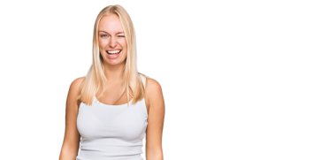 Kolsuz gömlekli genç sarışın kız kameraya seksi bir ifadeyle bakıyor, neşeli ve mutlu bir yüzle.. 