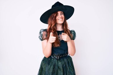 Cadılar Bayramı kostümü giymiş genç ve güzel bir kadın mutlu ve komik yüzüyle kamerayı işaret ediyor. iyi enerji ve titreşimler. 