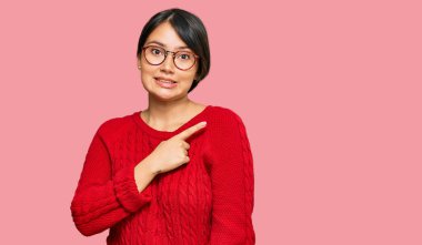 Kısa saçlı, sıradan süveter giyen ve gözlük takan genç ve güzel İspanyol bir kadın endişeli ve endişeli bir ifade takınıyor. 