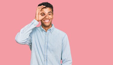 Genç, yakışıklı, Afro-Amerikalı, günlük kıyafetler giyen, el hareketleriyle gülümseyen, mutlu yüzüyle parmaklarının arasından bakan biri.. 