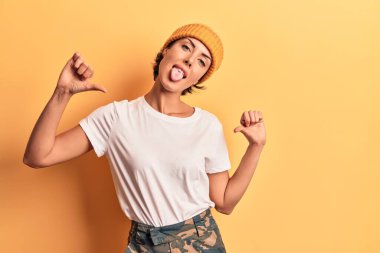 Yün şapka takan, kendine güvenen, gülümseyen, kendini gururlu ve mutlu gösteren genç bir kadın.. 