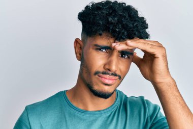 Gündelik giysiler giyen genç Arap yakışıklı adam elleri kafasında, şaşırmış ve sinirli yüzüyle stresli. 