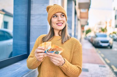 Genç sarışın kadın gülerek şehirde İsviçre frangı banknotlarını sayıyor..