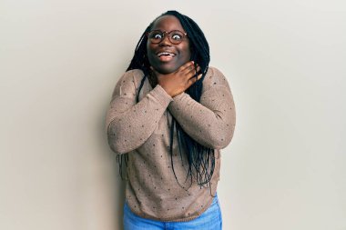 Saçları örgülü, sıradan kıyafetler ve gözlüklü genç siyahi kadın bağırıyor ve boğuluyor çünkü acı verici bir boğulma var. Sağlık problemi. Boğulma ve intihar konsepti. 