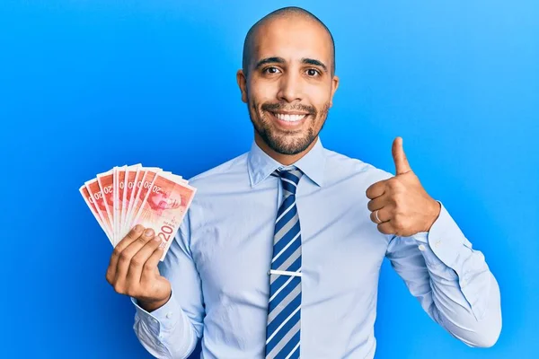 Hispanic Adult Man Holding Israel Shekels Banknotes Smiling Happy Positive — Stock Photo, Image