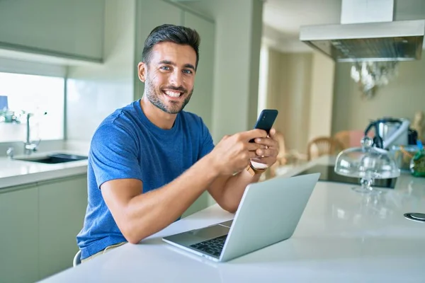 Joven Hombre Guapo Sonriendo Feliz Trabajando Con Teléfono Inteligente Portátil — Foto de Stock