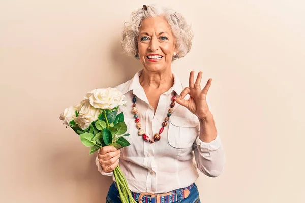 Mulher Cabelos Grisalhos Sênior Segurando Flores Fazendo Sinal Com Dedos — Fotografia de Stock