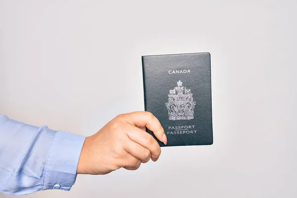 持加拿大加拿大护照的高加索裔年轻妇女在孤立的白人背景下的手 — 图库照片