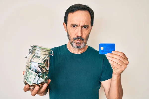 Orta Yaşlı Spanyol Bir Adamın Elinde Kredi Kartı Kavanozla Şüpheci — Stok fotoğraf