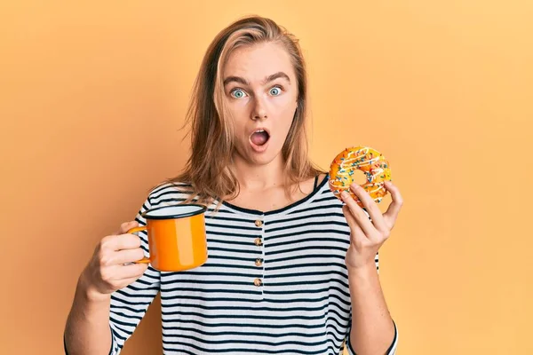 Hermosa Mujer Rubia Comiendo Donut Bebiendo Café Cara Choque Mirando —  Fotos de Stock