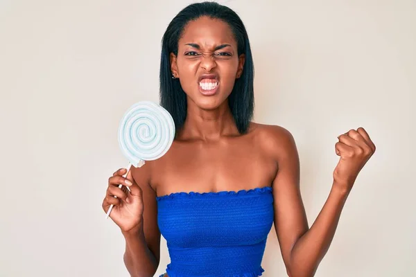 Joven Mujer Afroamericana Sosteniendo Caramelos Azúcar Molesto Frustrado Gritando Con —  Fotos de Stock