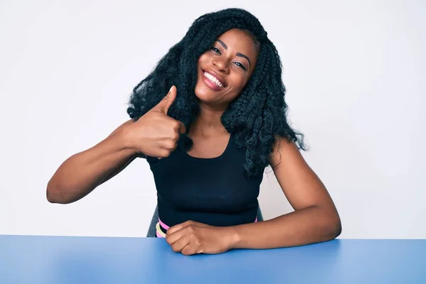 Schöne Afrikanische Frau Lässiger Kleidung Sitzt Auf Dem Tisch Und — Stockfoto