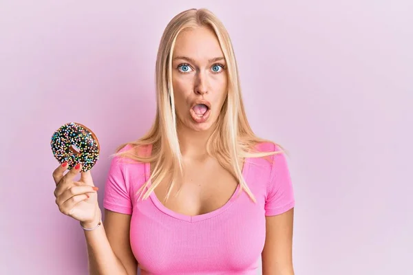 Jovem Loira Segurando Donut Assustado Surpreso Com Boca Aberta Para — Fotografia de Stock