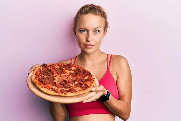 イタリアのピザを保持する美しい白人女性懐疑的で緊張 問題のために動揺を眉をひそめて 否定的な人 — ストック写真