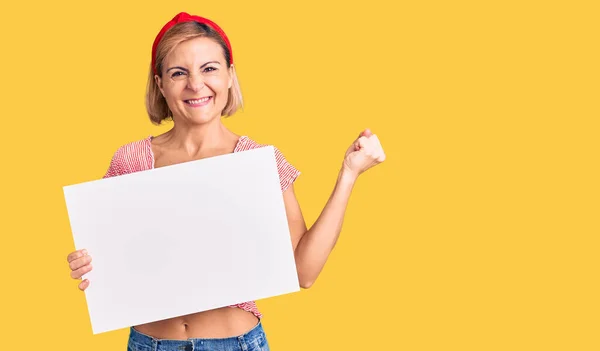 Mujer Rubia Joven Sosteniendo Banner Vacío Blanco Gritando Orgulloso Celebrando —  Fotos de Stock