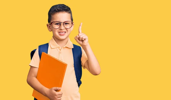 Pequeno Garoto Bonito Usando Saco Escolar Segurando Livro Surpreso Com — Fotografia de Stock