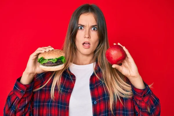 Όμορφη Καυκάσια Γυναίκα Σύγκριση Burger Και Υγιή Κόκκινο Μήλο Στο — Φωτογραφία Αρχείου