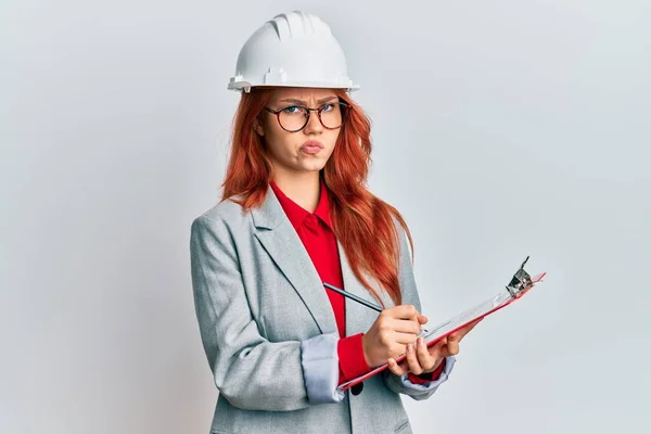 Ung Rödhårig Kvinna Klädd Arkitekt Hardhat Skeptisk Och Nervös Rynka — Stockfoto