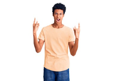 Sıradan kıyafetler giymiş, çılgın bir ifadeyle bağıran, elleri havada rock sembolü yapan genç bir Afrikalı Amerikalı. Müzik yıldızı. ağır kavram. 