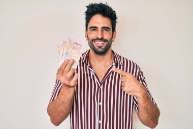 Yakışıklı, sakallı, Birleşik Krallık 'ı elinde tutan yakışıklı, mutlu, eli ve parmağı olan bir adam. 