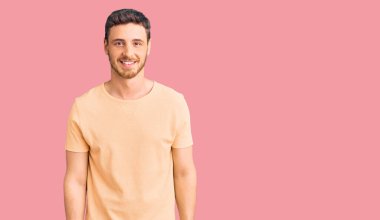 Yüzünde mutlu ve havalı bir gülümseme olan sıradan sarı tişörtlü yakışıklı bir ayı. şanslı kişi. 