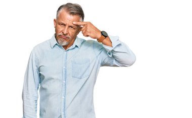 Orta yaşlı, gri saçlı, sıradan kıyafetler giyen, alnındaki sivilceden memnun olmayan, siyah başlıklı, çirkin bir enfeksiyon. sivilce ve deri problemi 