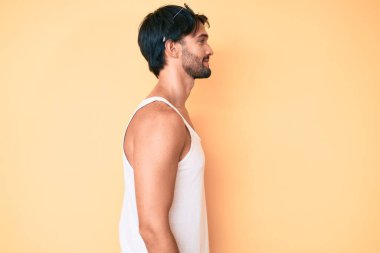 Yaz görünüşü ve güneş gözlüğü takan yakışıklı İspanyol bir adam. Taraf arıyor, rahat poz veriyor, kendine güvenen bir gülümsemesi var.. 