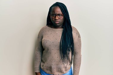 Saçları örgülü, gözlüklü, kuşkucu ve gergin genç siyahi bir kadın sorun yüzünden üzgün. negatif kişi. 