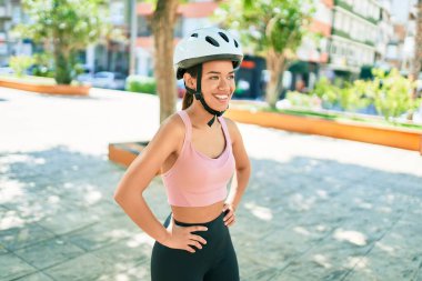 Kasabada bisiklet kaskı takarak gülümseyen güzel İspanyol bisikletçi kadın.