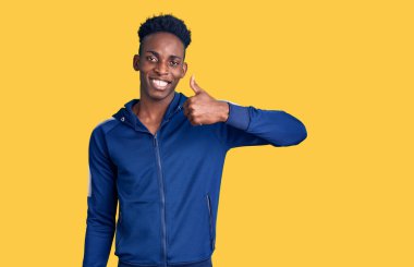 Genç Afro-Amerikan erkek spor giysisi giyerek mutlu bir jest yapıyor. Kameraya bakıp başarıyı gösteren ifade. 
